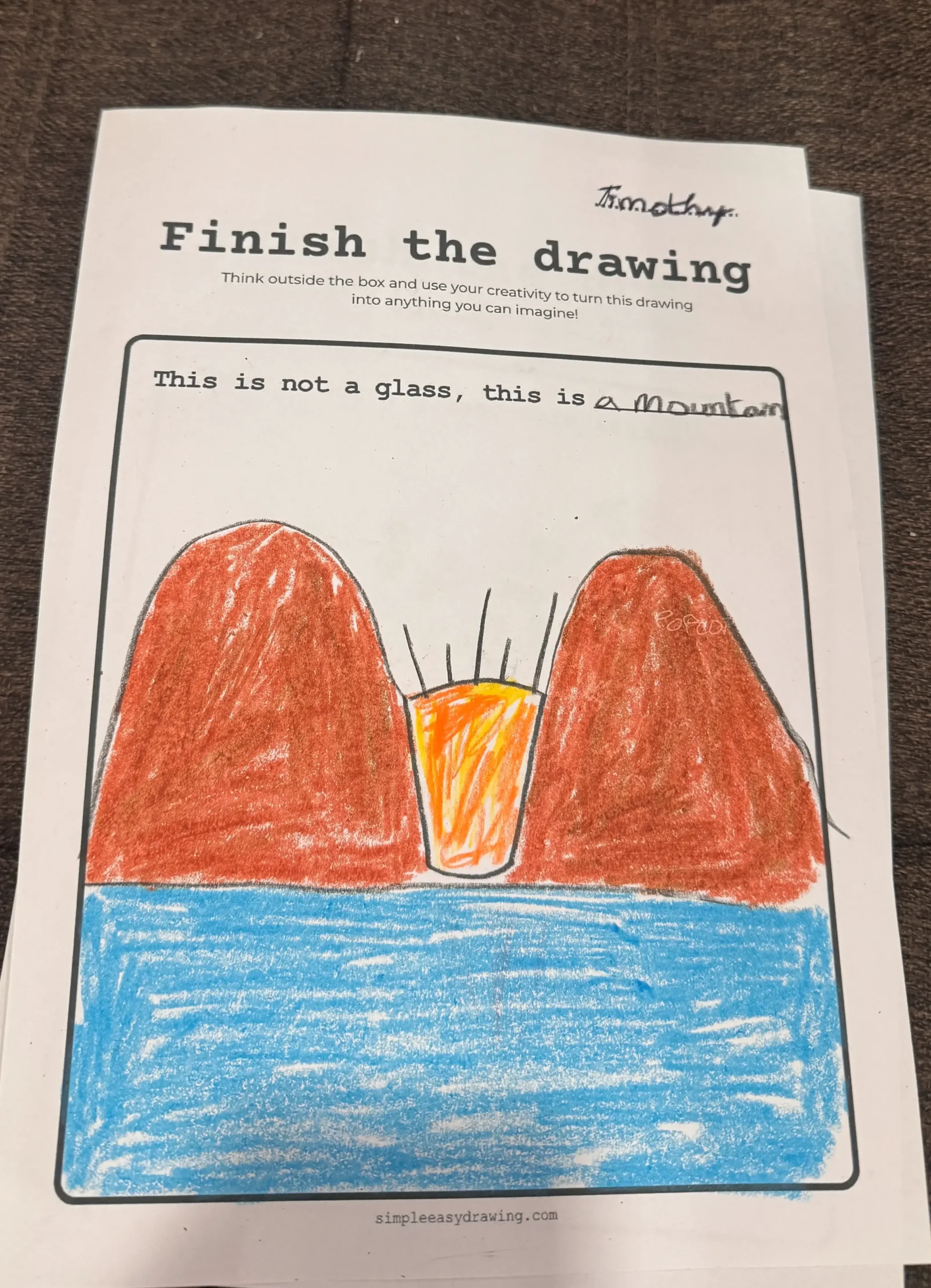 Finish the Drawing Worksheet with a glass turned into a mountain scene with mountains, sun, and water.