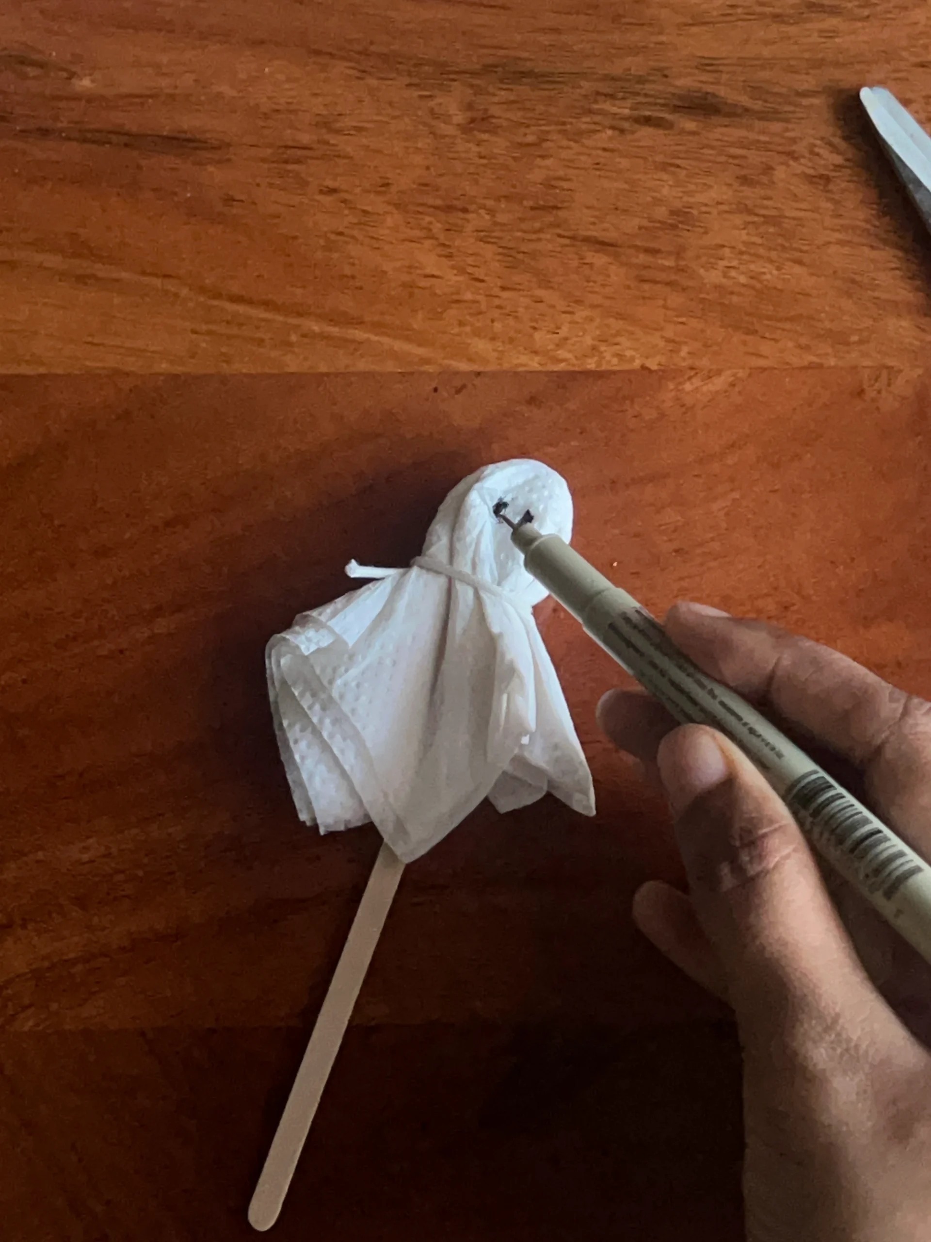 Drawing eyes on a handmade tissue paper Halloween ghost
